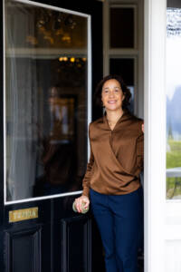 Image of Marina Silva the hotel manager at Hulbetr House opening the front door to welcome guests
